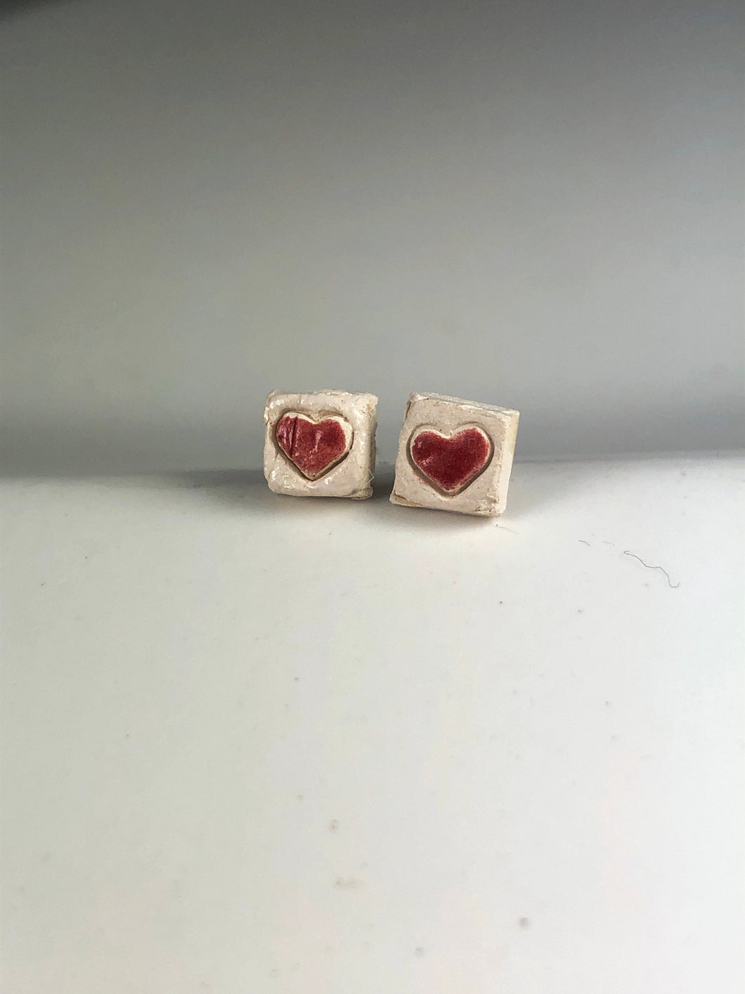 red hearts on white ceramic studs