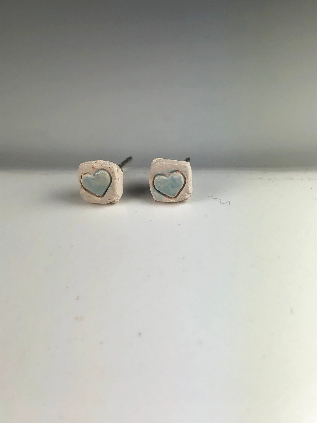 blue hearts on white ceramic studs